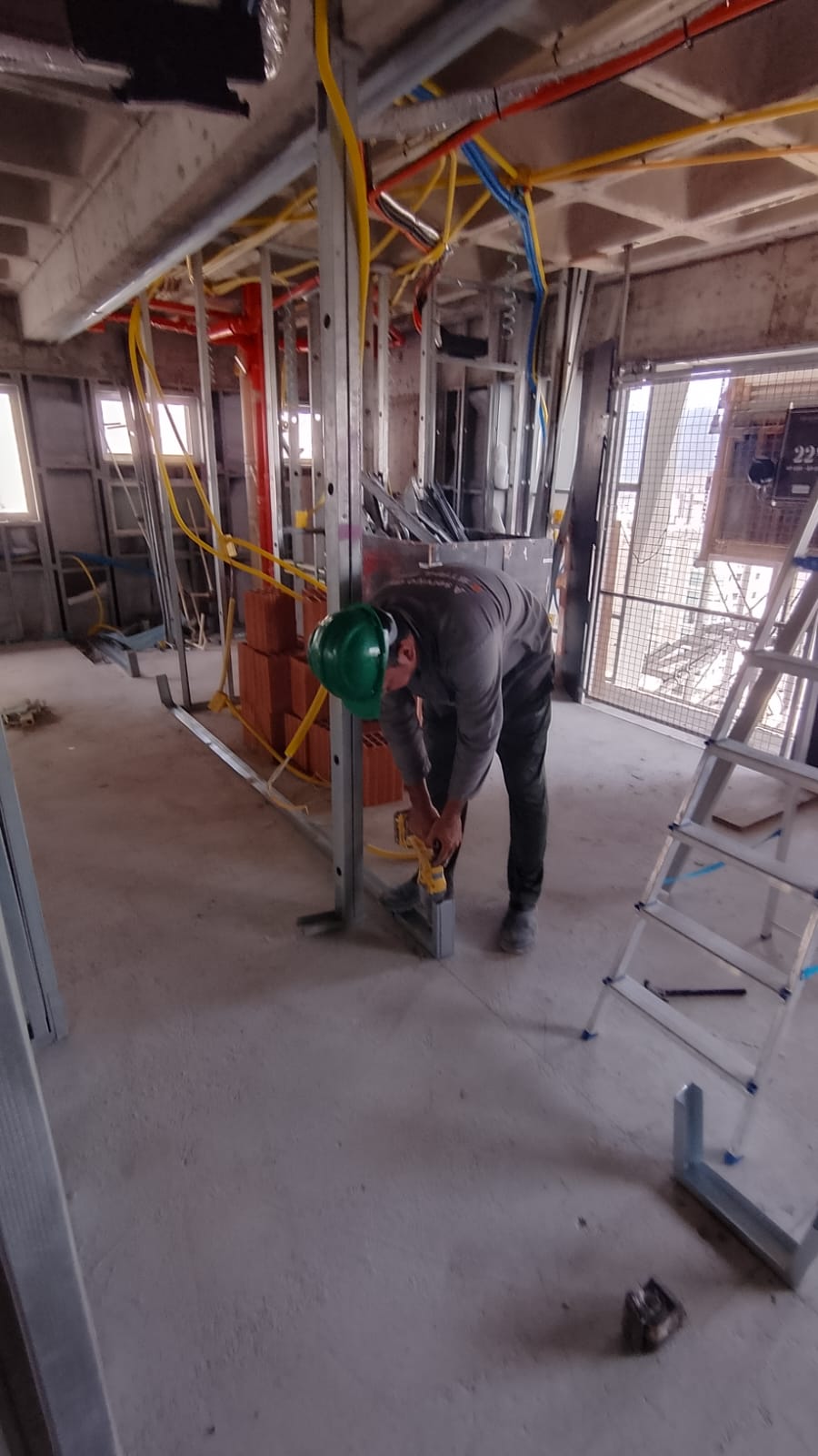 Fixação das guias no piso durante a montagem da estrutura em drywall
